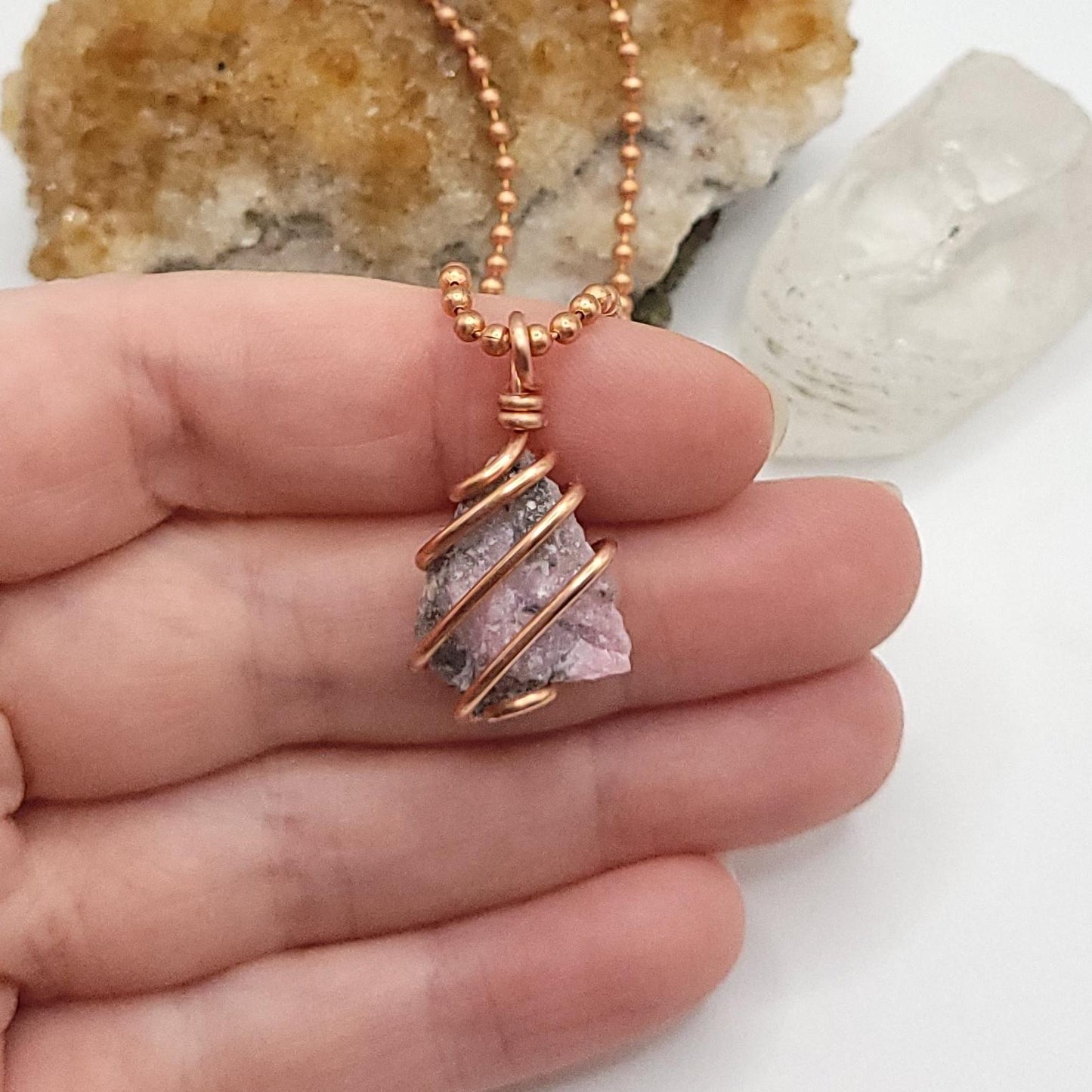 Raw Pink Moonstone Crystal Necklace in Copper in hand