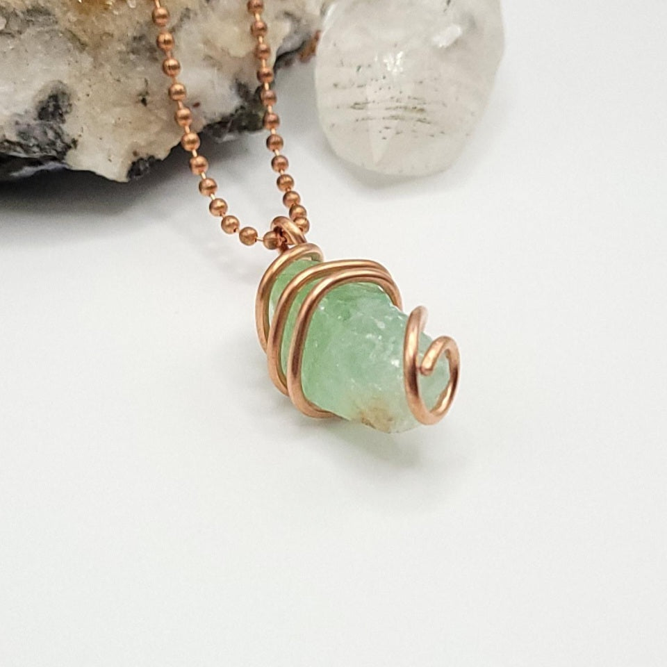 Raw green calcite necklace in copper showcasing soothing vibes and heart healing properties.