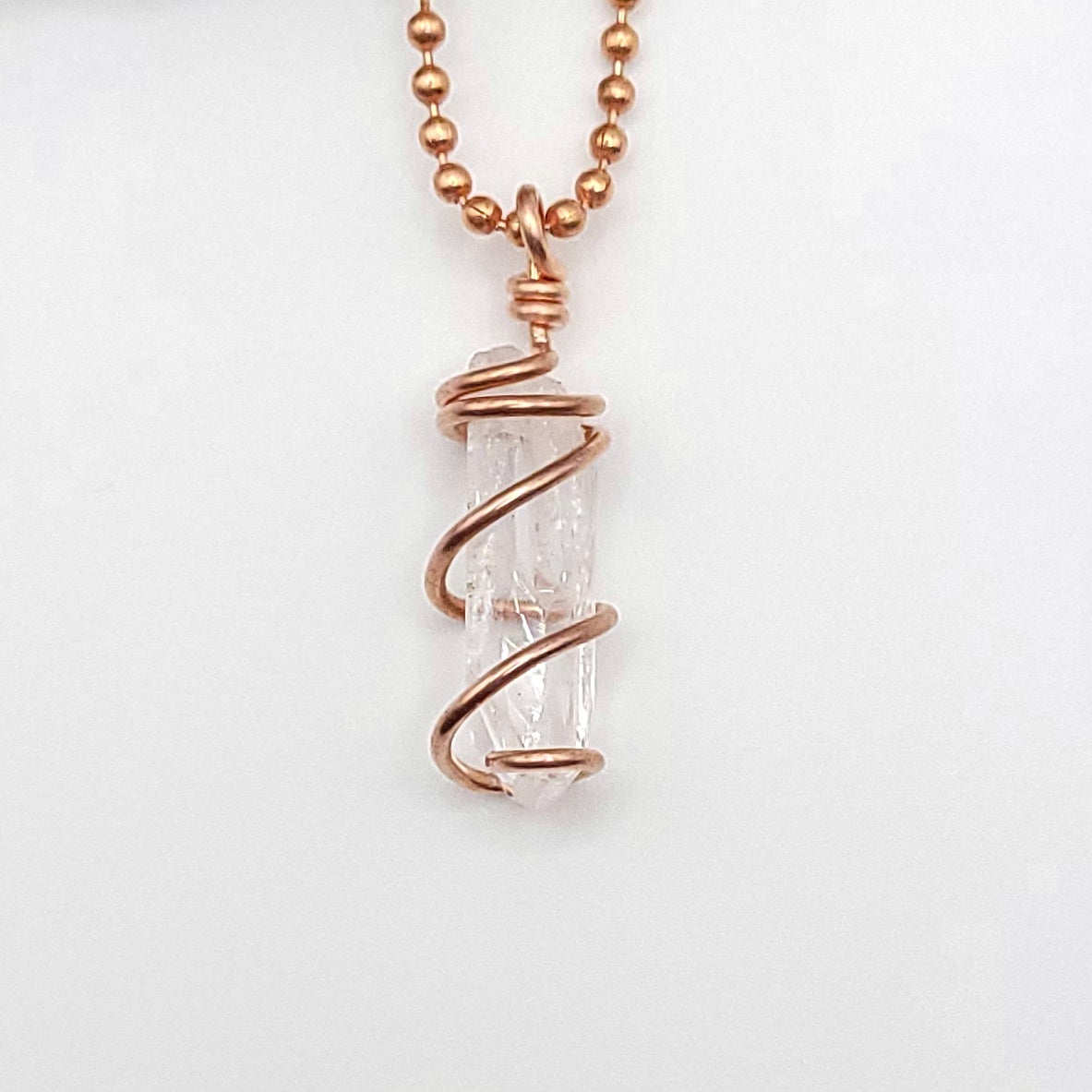 raw danburite pendant in copper on white background