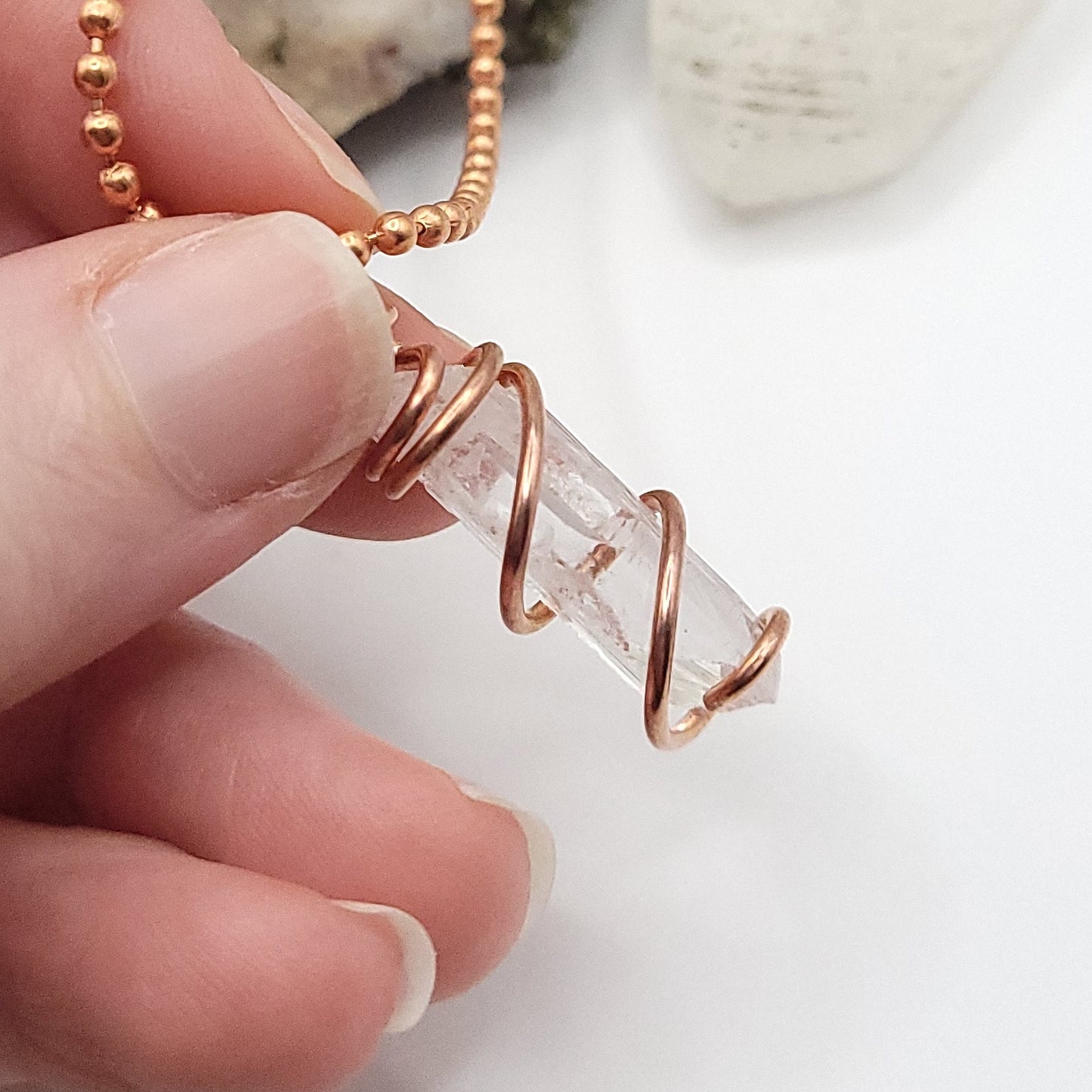 raw danburite pendant in copper on neutral background