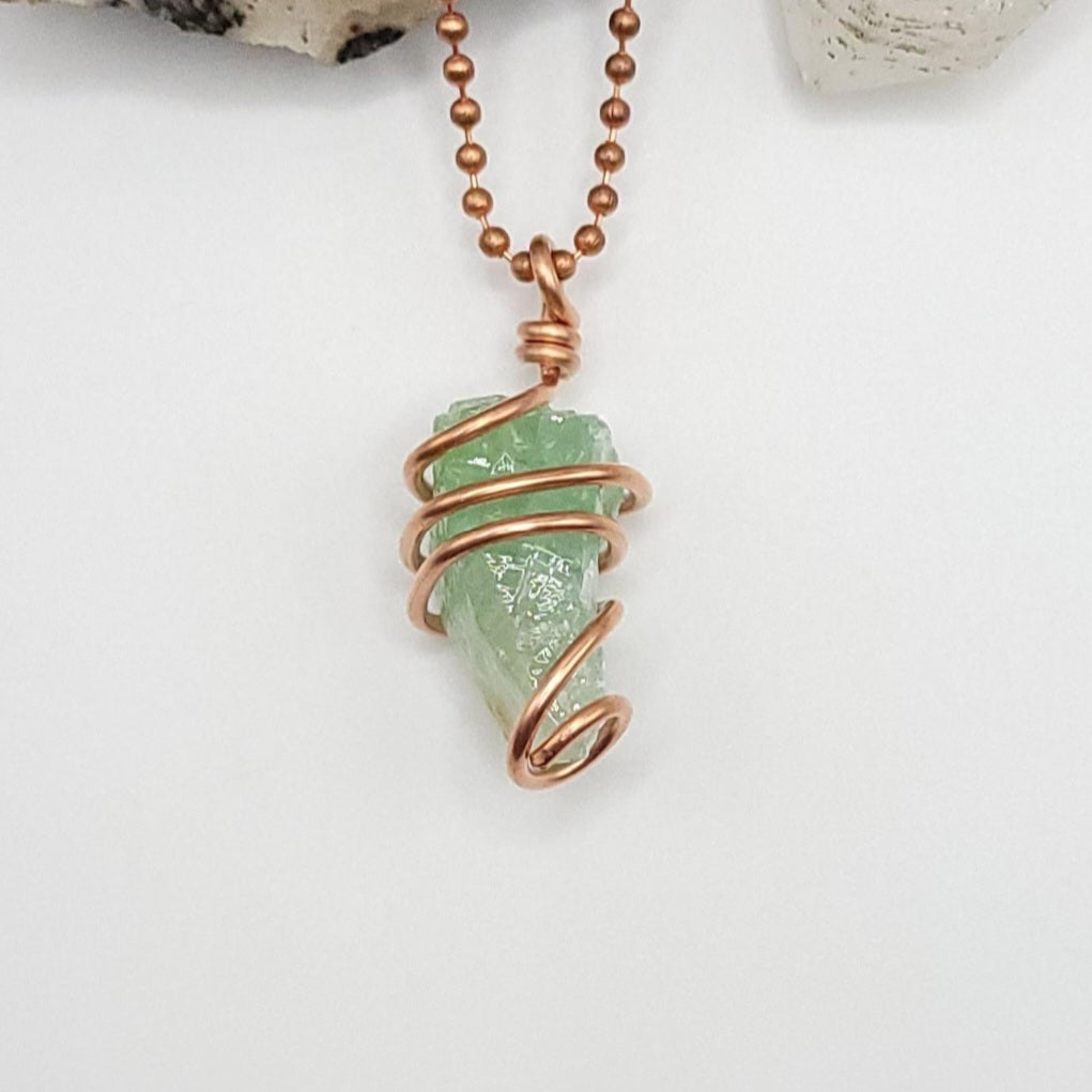 Raw green calcite necklace wrapped in copper, showcasing its transformative beauty and healing properties.