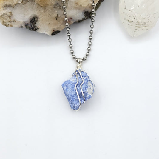 A sodalite crystal wrapped in silver wire with a stainless-steel ball chain