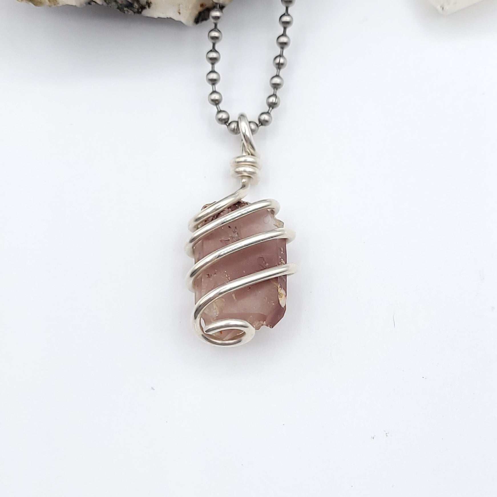 lithium quartz necklace in sterling silver wire on white background close up