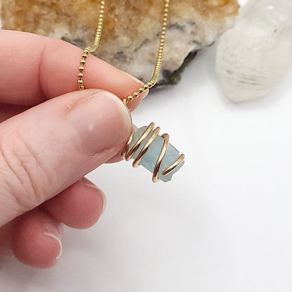 Raw Aquamarine Crystal Necklace in Gold wire, against light