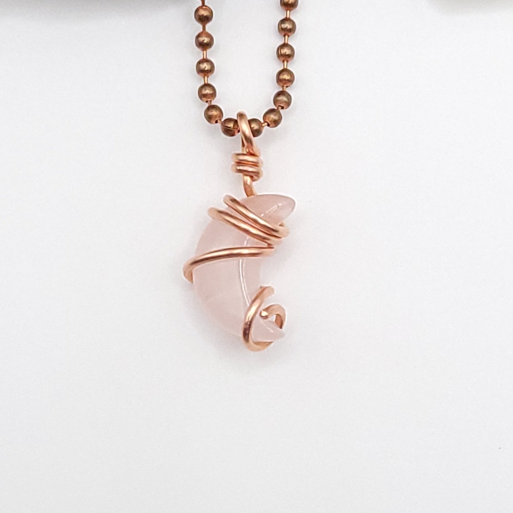 Rose quartz Crescent Moon crystal necklace in copper close up