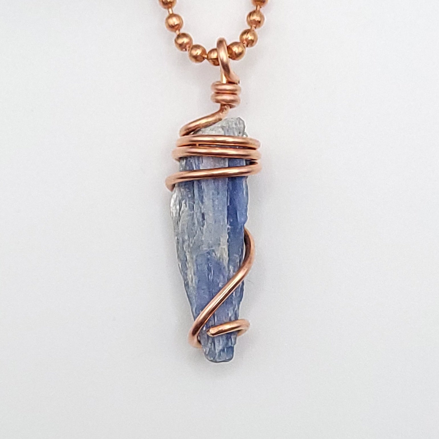 raw blue kyanite necklace in copper on white background close up