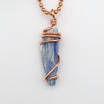 raw blue kyanite necklace in copper on white background close up