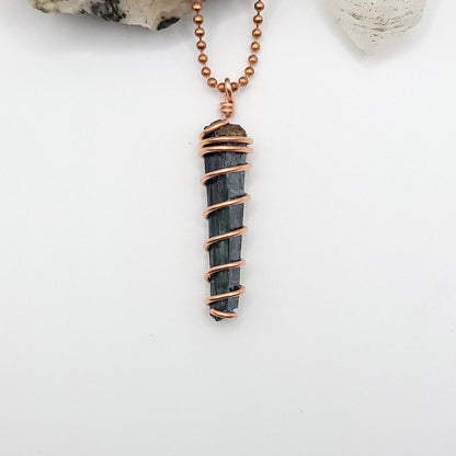 vivianite in copper wire pendant on white background