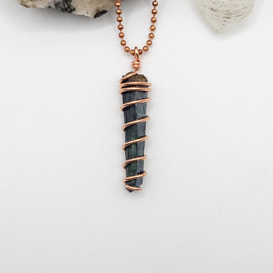 vivianite in copper wire pendant on white background