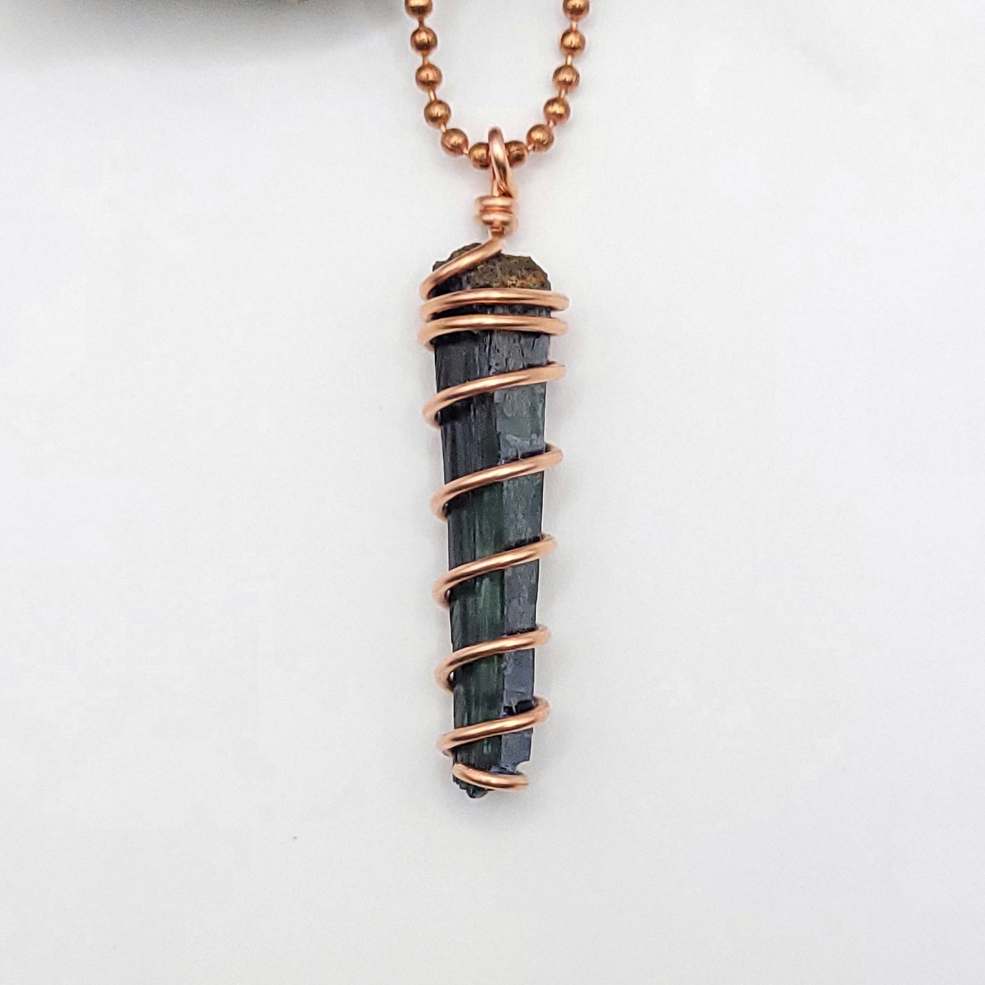 close up of vivianite pendant in copper wire