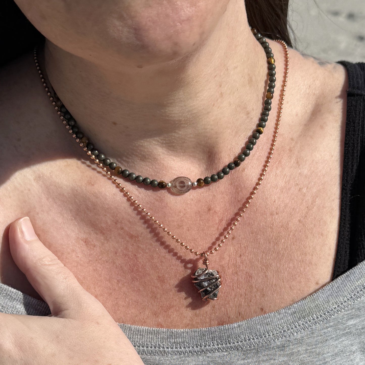 Smoky Quartz Evil Eye Necklace with Pyrite and Tiger’s Eye beads for grounded confidence, layered with other necklaces.