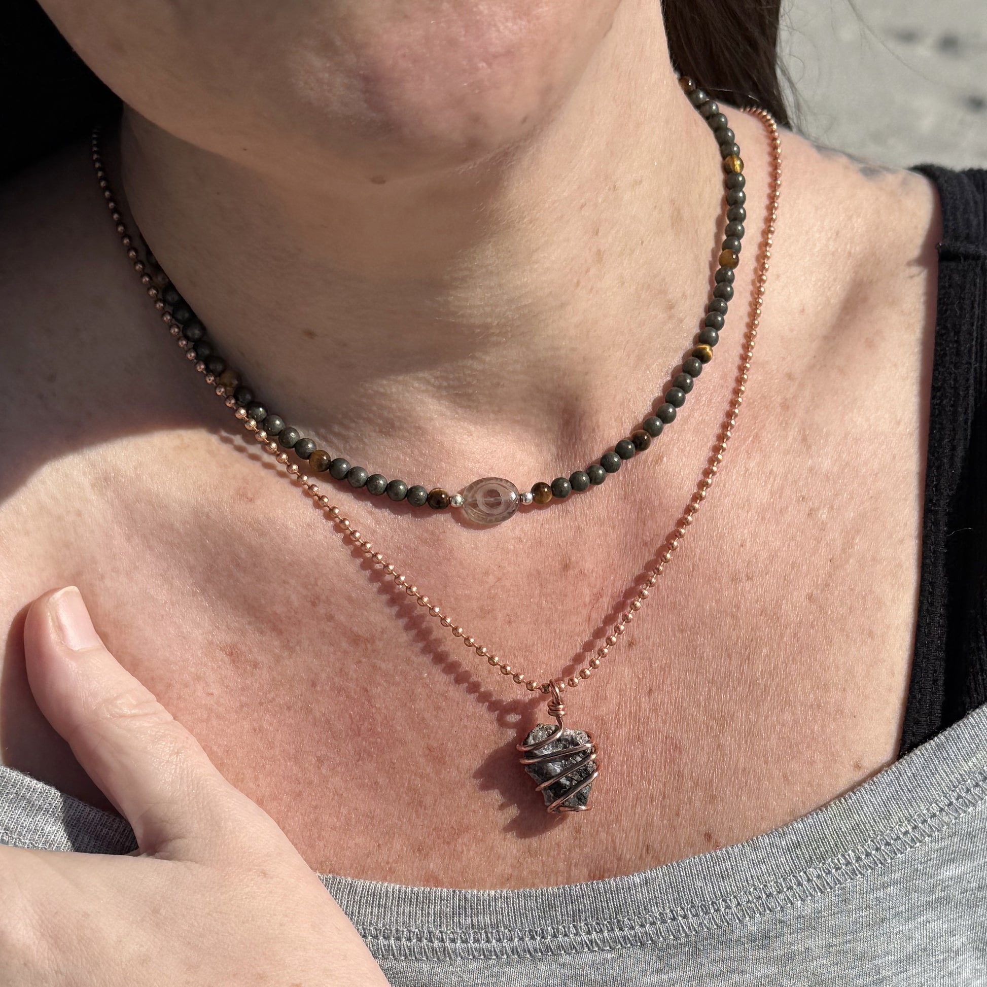 Smoky Quartz Evil Eye Necklace with Pyrite and Tiger’s Eye beads for grounded confidence, layered with other necklaces.