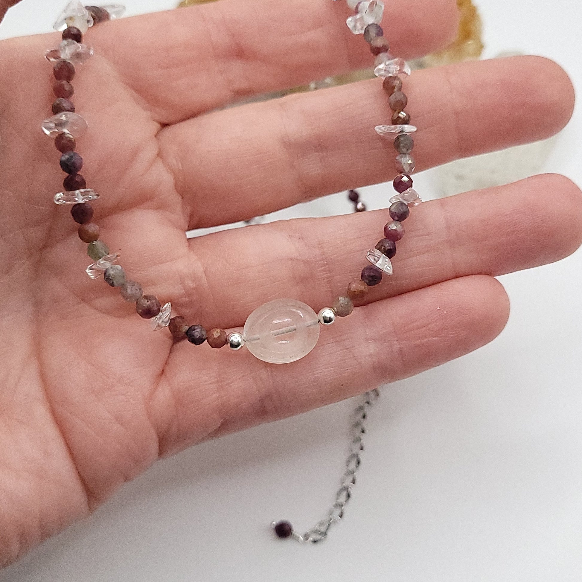 Clear Quartz Evil Eye Necklace featuring Multi-Color Tourmaline chip beads in a hand, showcasing vibrant energy and protection.