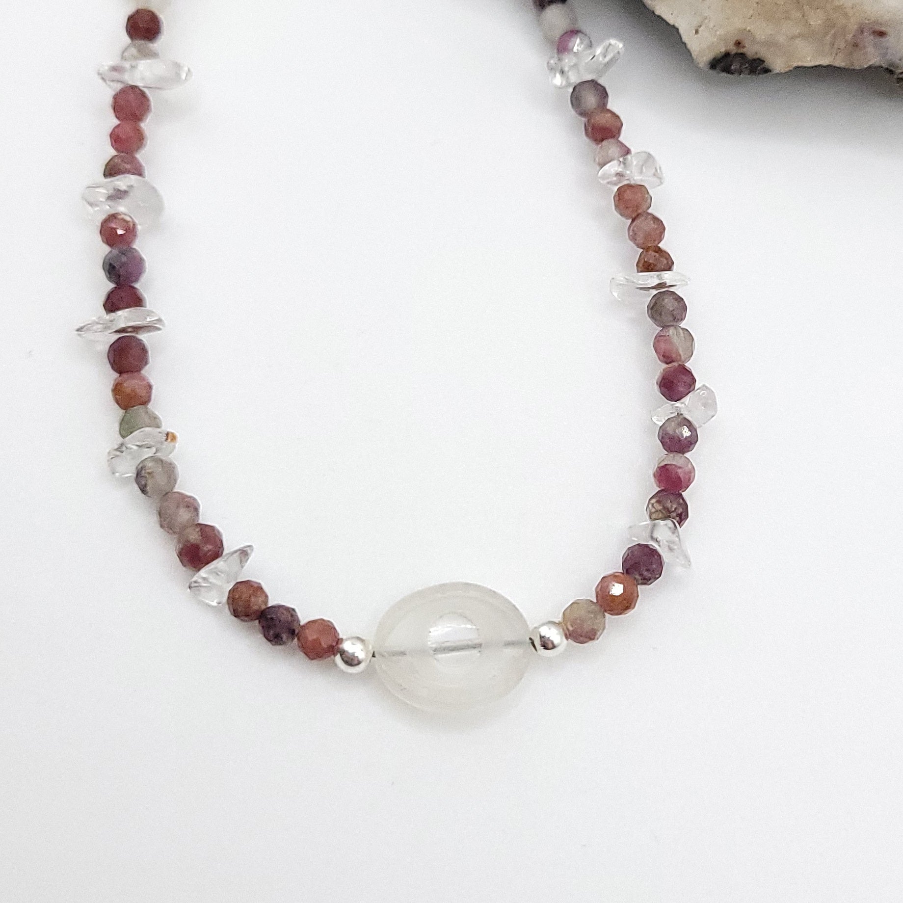 Clear quartz evil eye necklace with multi-color tourmaline beads for energy balance and protection.