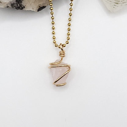 raw rose quartz necklace wrapped in gold, showcasing the loving energy of rose quartz.