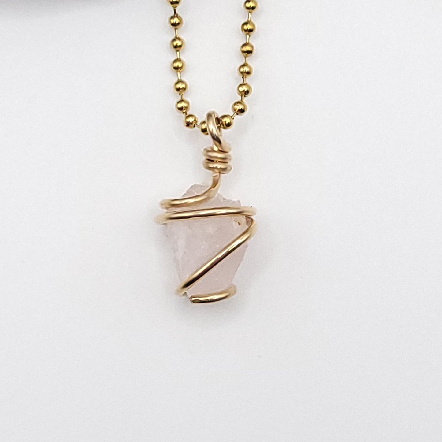 Raw rose quartz necklace in gold, featuring authentic raw rose quartz wrapped in 14k gold filled wire, promoting love and compassion.