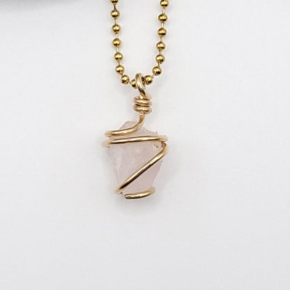 Raw rose quartz necklace in gold, featuring authentic raw rose quartz wrapped in 14k gold filled wire, promoting love and compassion.
