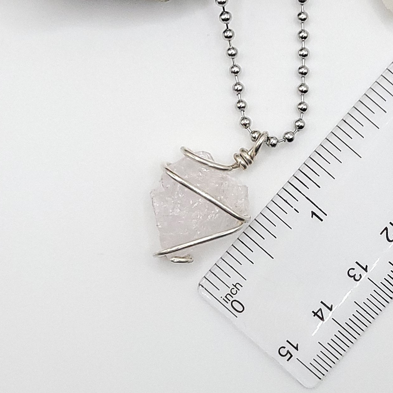 raw rose quartz necklace in sterling silver next to ruler measuring just over 1 inch