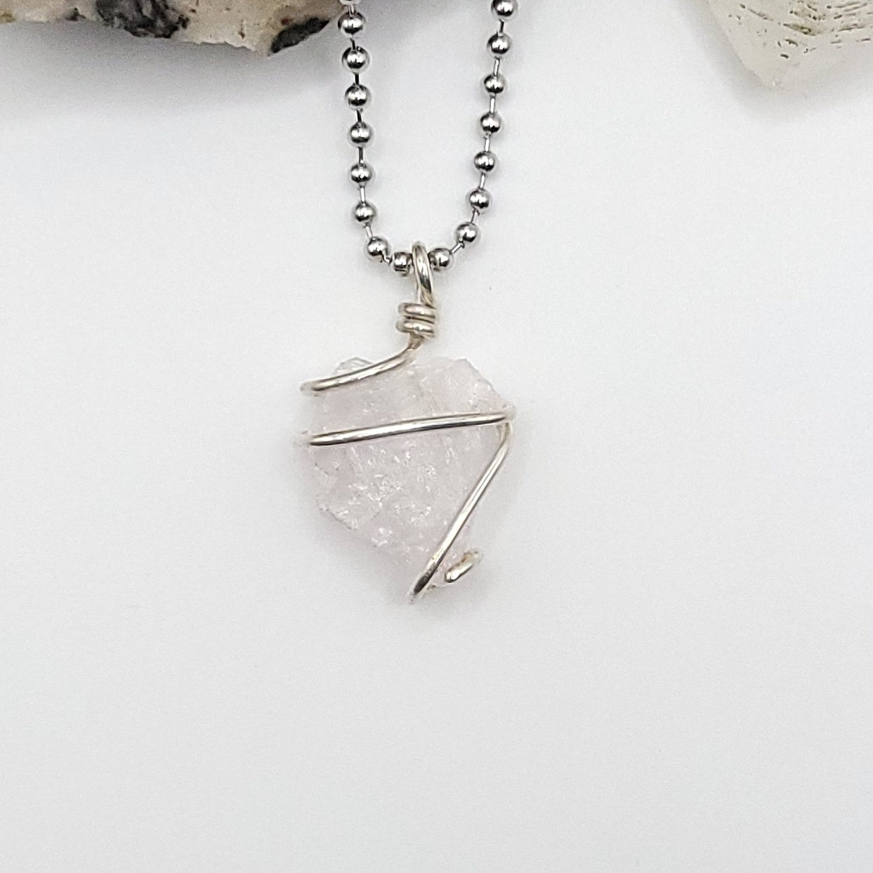 raw rose quartz necklace in sterling silver on white background