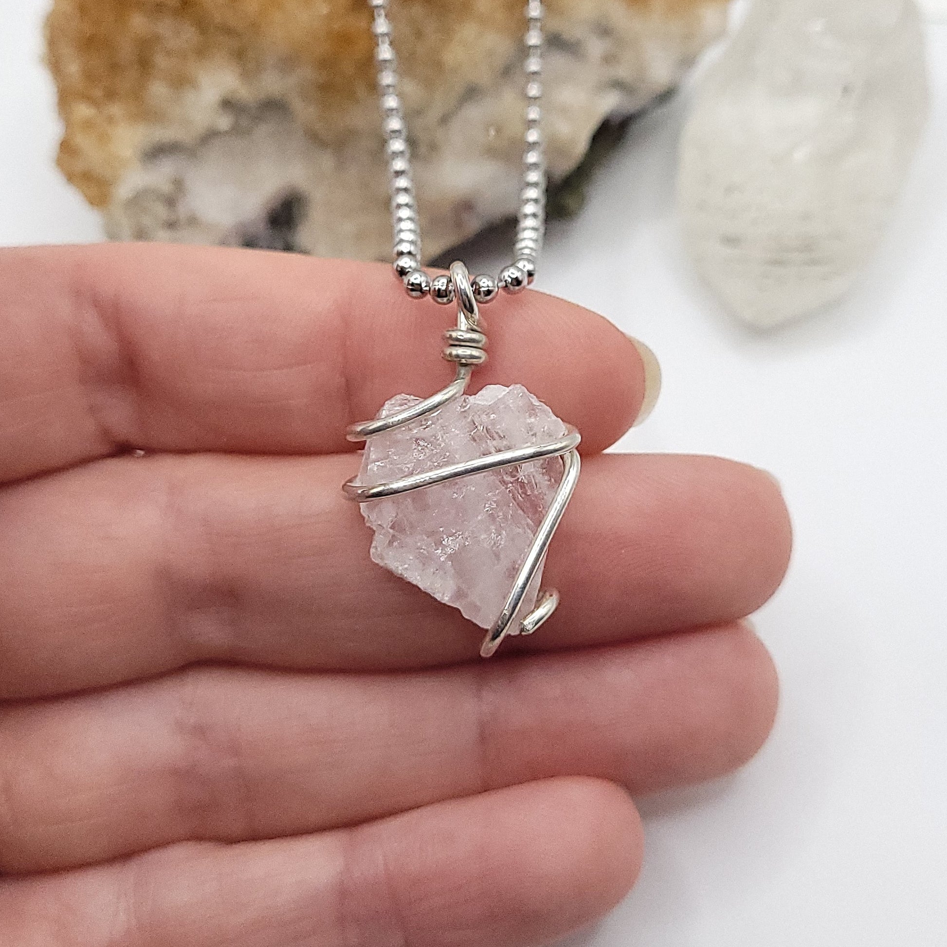 raw rose quartz necklace in sterling silver in hand