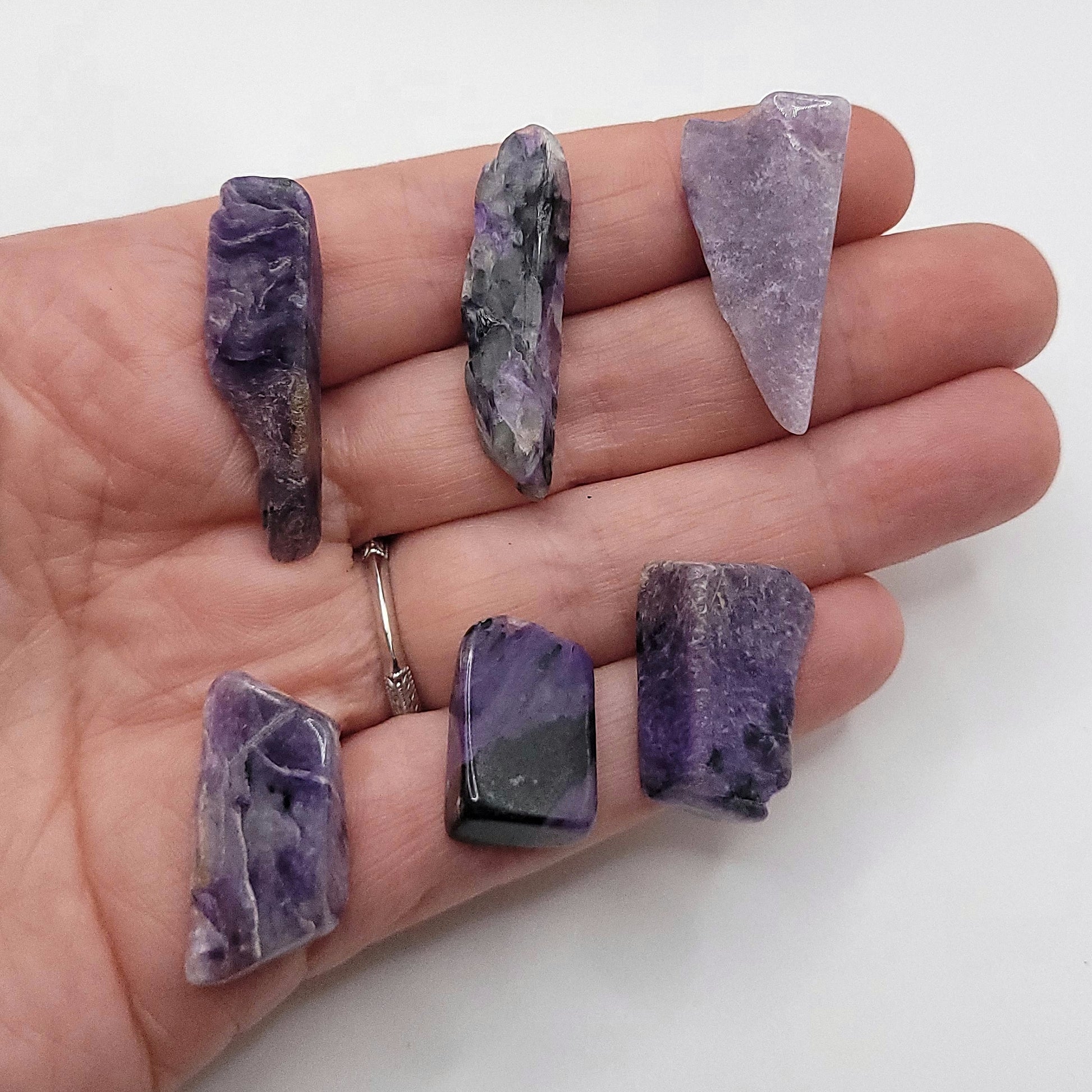 6 charoite stones in hand to choose from for custom charoite necklace