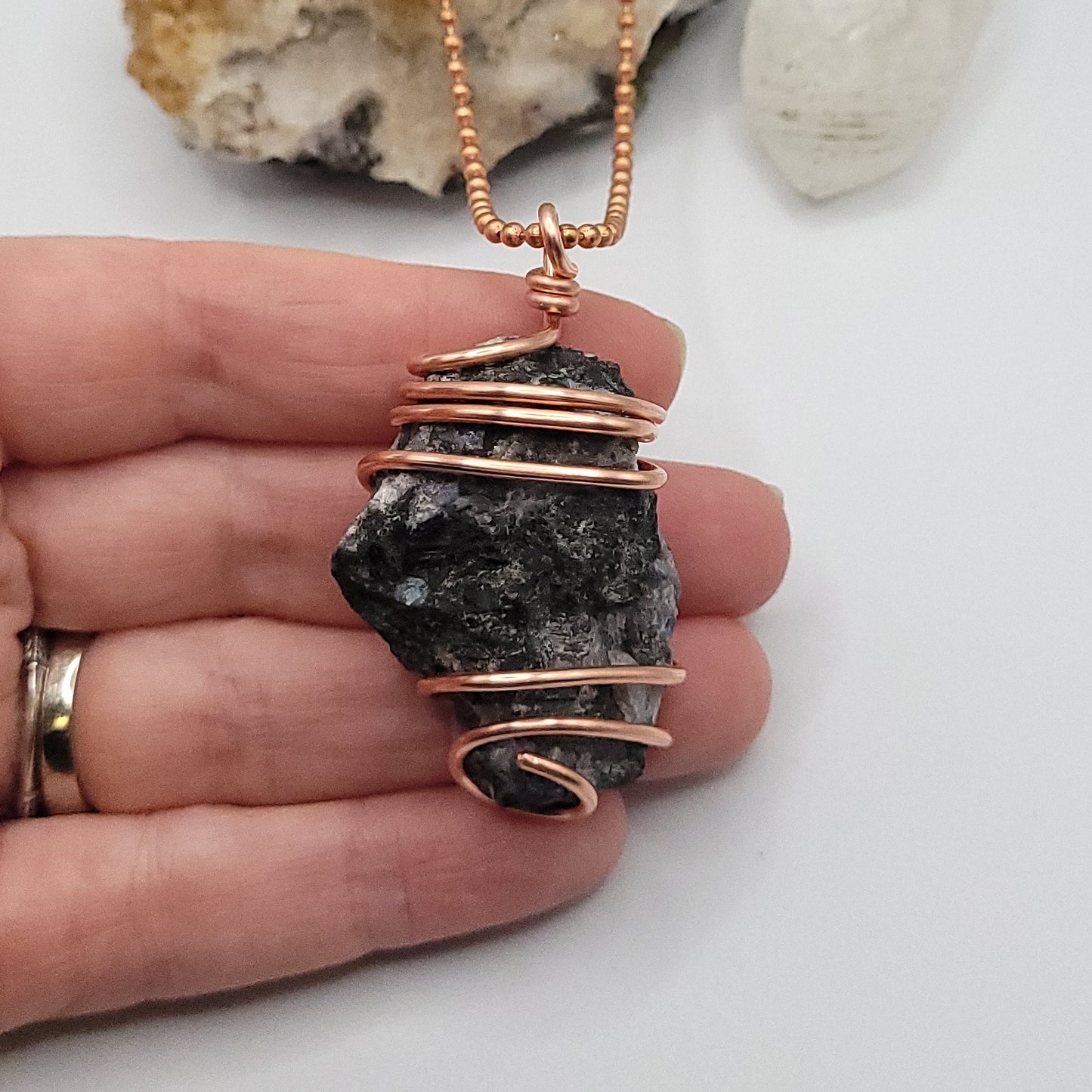 raw mystic merlinite necklace in copper wire on a copper ball chain in hand