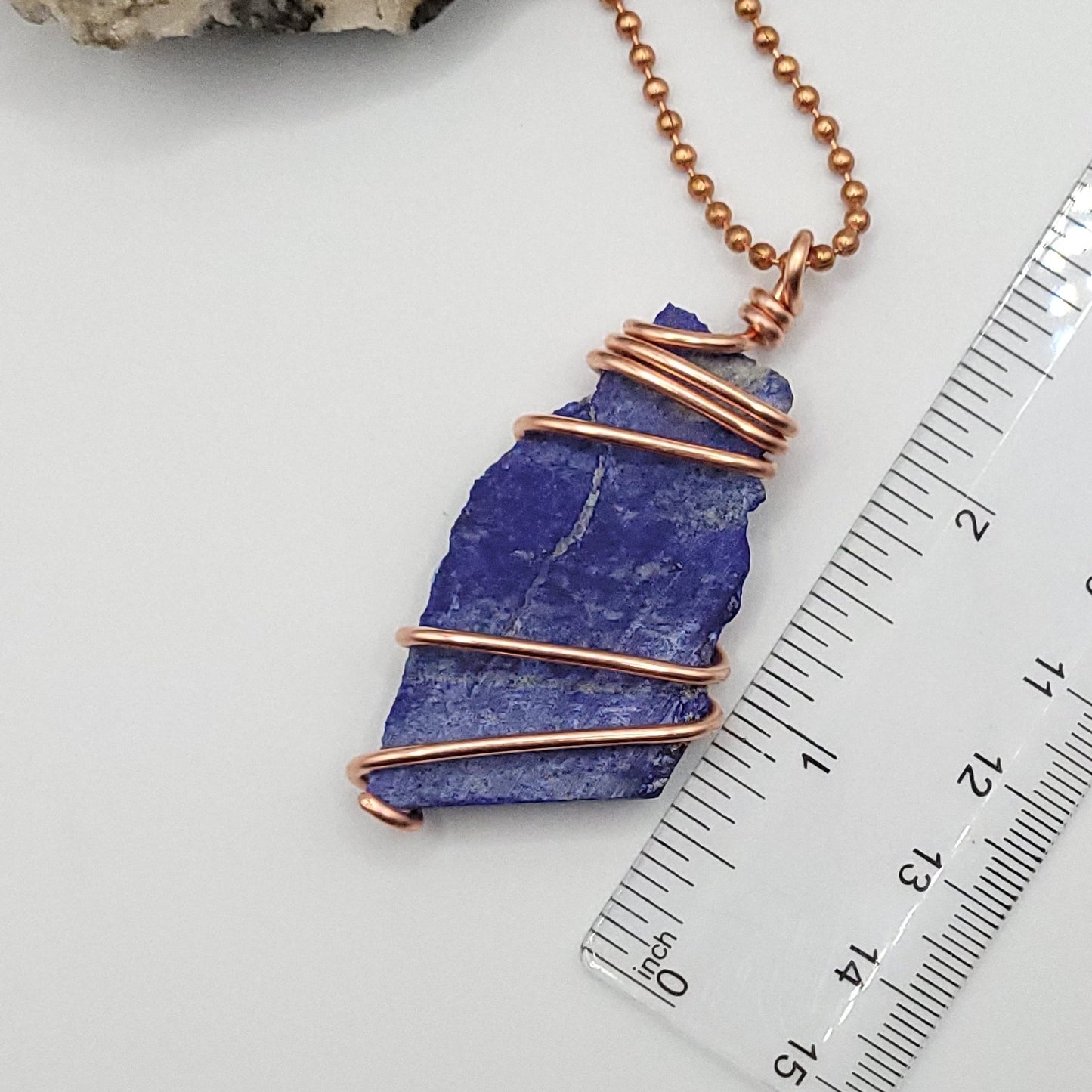 lapis lazuli necklace in copper wire on a copper ball chain next to ruler , measuring about 2.5 inches