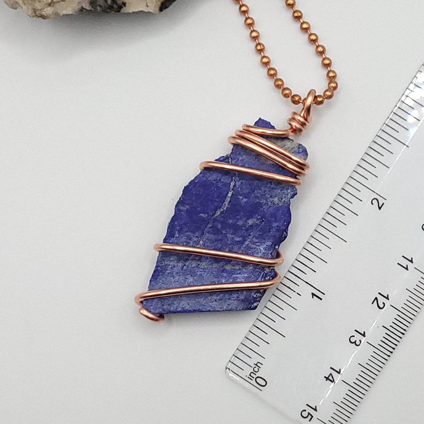 lapis lazuli necklace in copper wire on a copper ball chain next to ruler , measuring about 2.5 inches