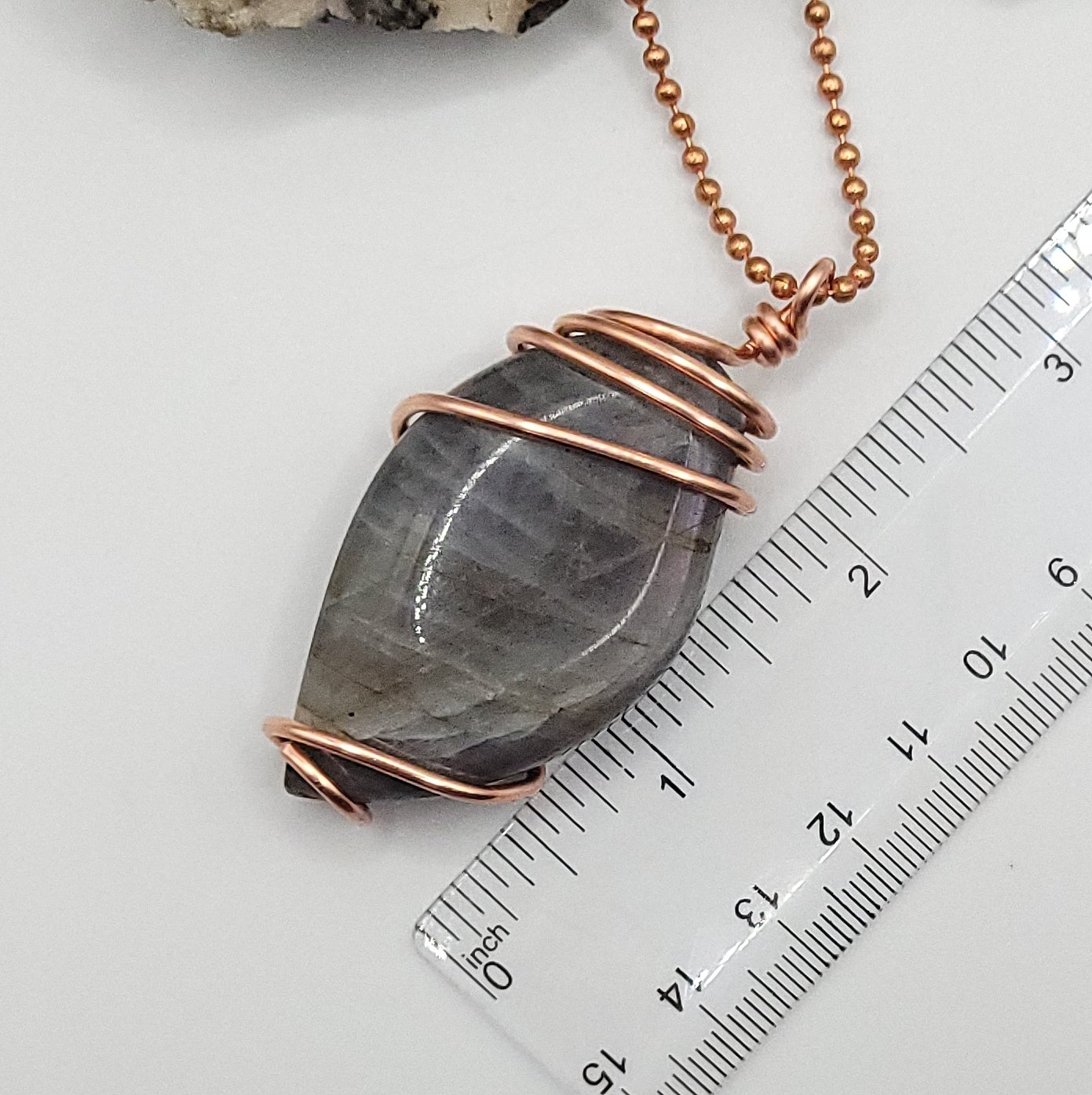 labradorite necklace in copper wire on a copper ball chain next to ruler , measuring just over 2.5 inches