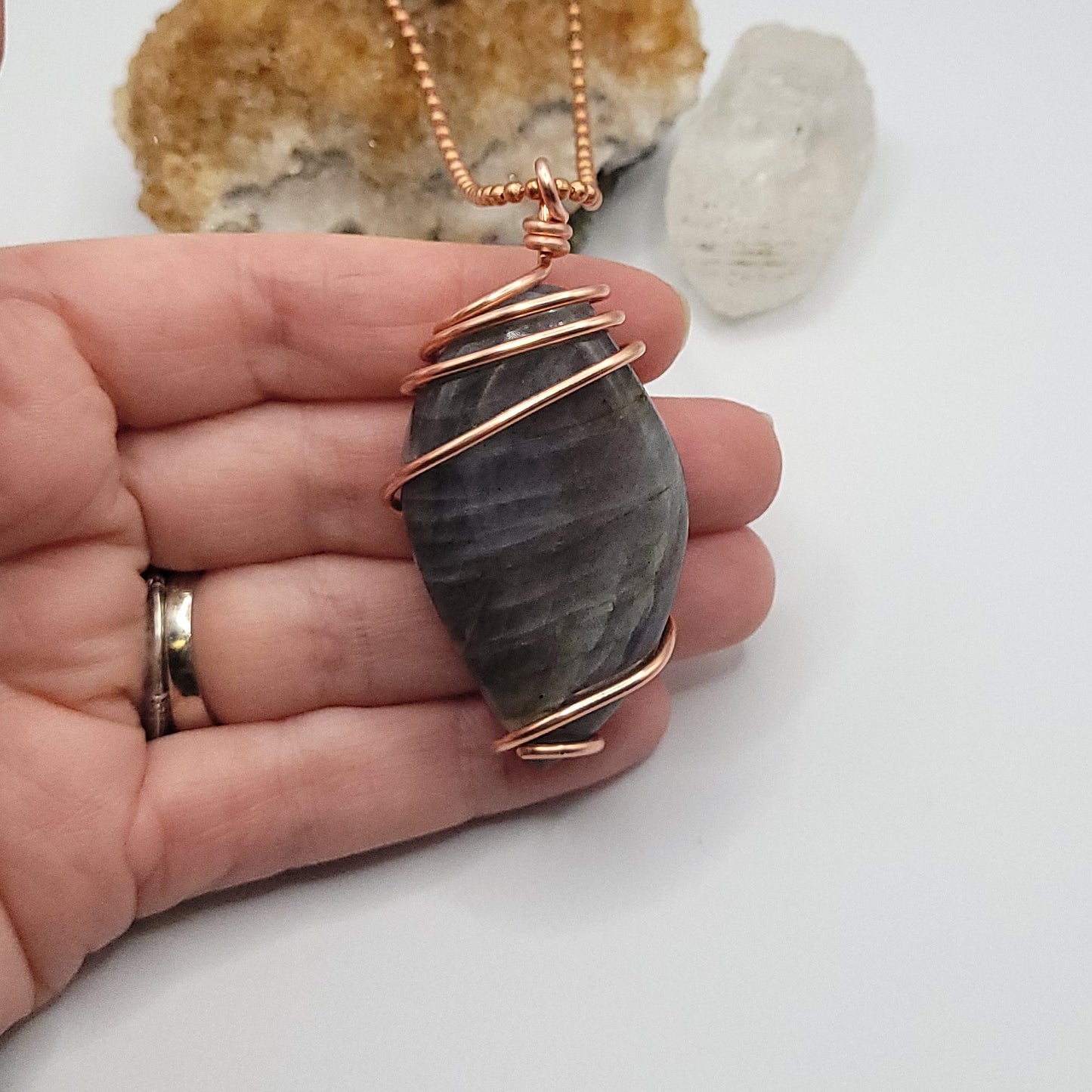 labradorite necklace in copper wire on a copper ball chain in hand