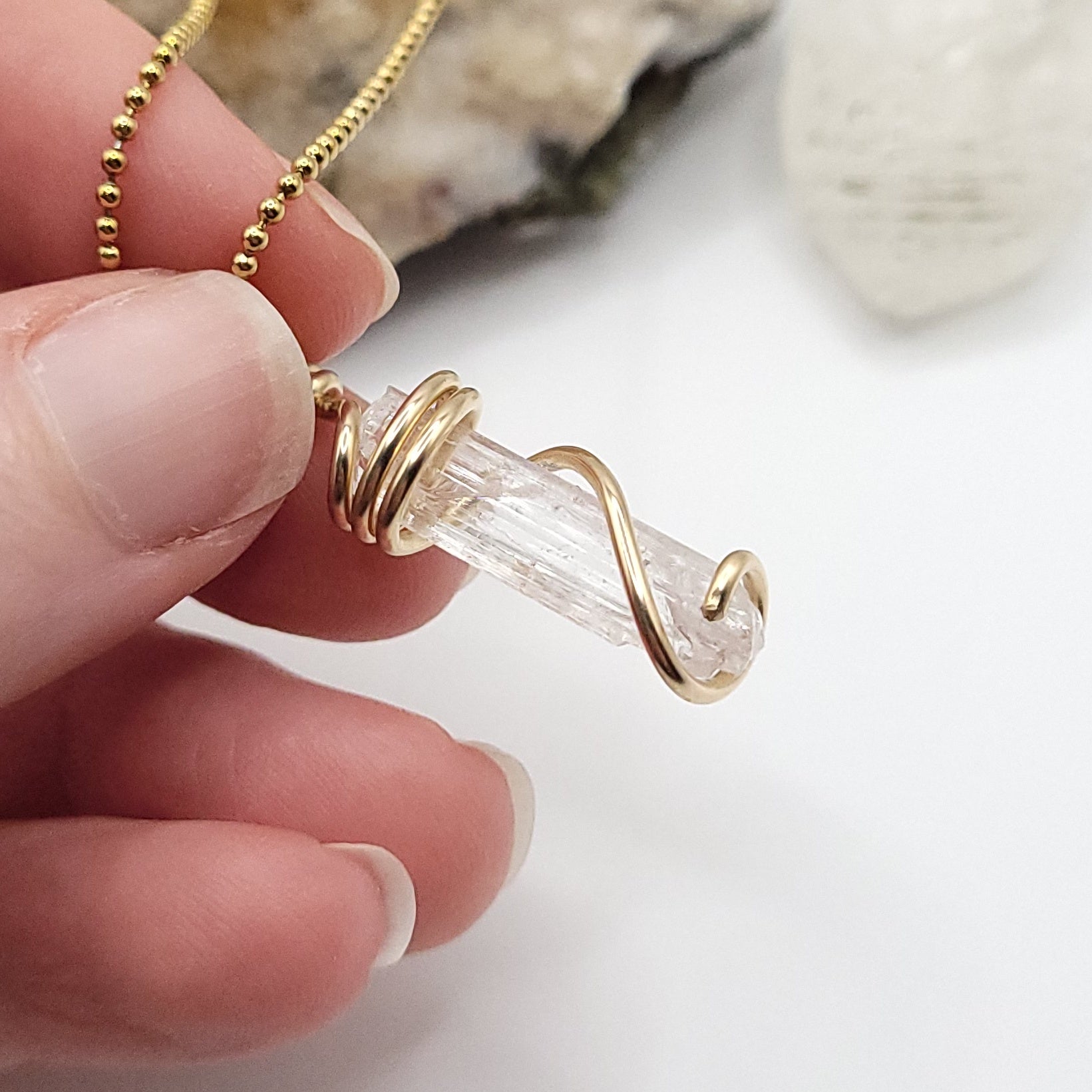 Raw Danburite Necklace in Gold against a neutral.