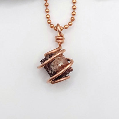 Raw zircon necklace wrapped in copper wire, promoting clarity and inner strength.