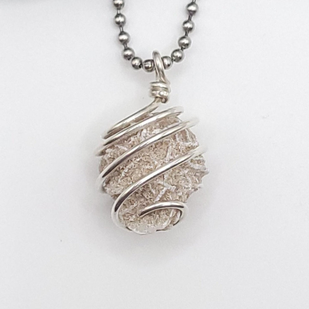 Silver wire-wrapped desert rose selenite pendant necklace on a white background close up