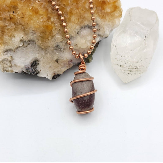 Necklace with a copper-wrapped shive lingam pendant on a white background