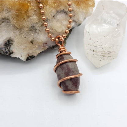 shiva lingam in copper wire necklace on white background