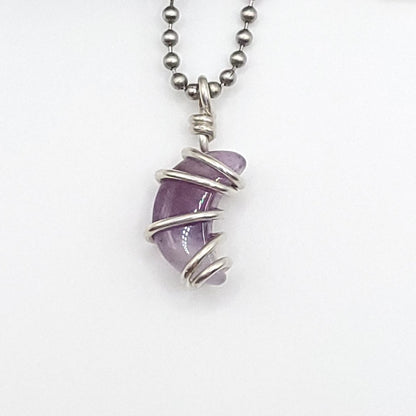 Handmade silver wire‑wrapped purple crystal pendant on a silver bead chain, shown against a white background.