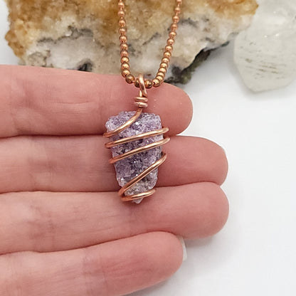 raw lepidolite necklace in copper wire in hand