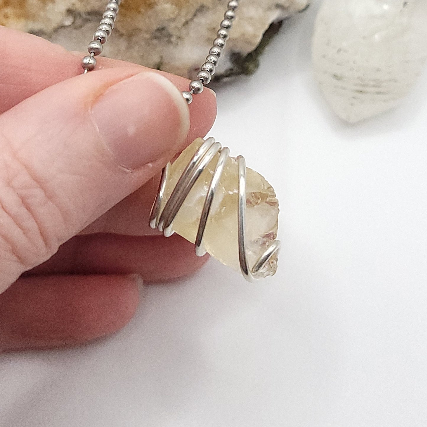 Raw Honey Calcite Necklace in Silver, showcasing a raw Honey Calcite stone wrapped in sterling silver wire.
