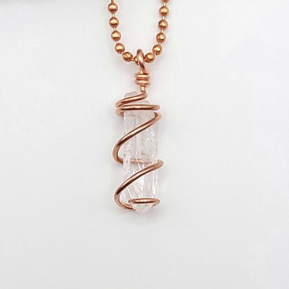 raw danburite pendant in copper on white background
