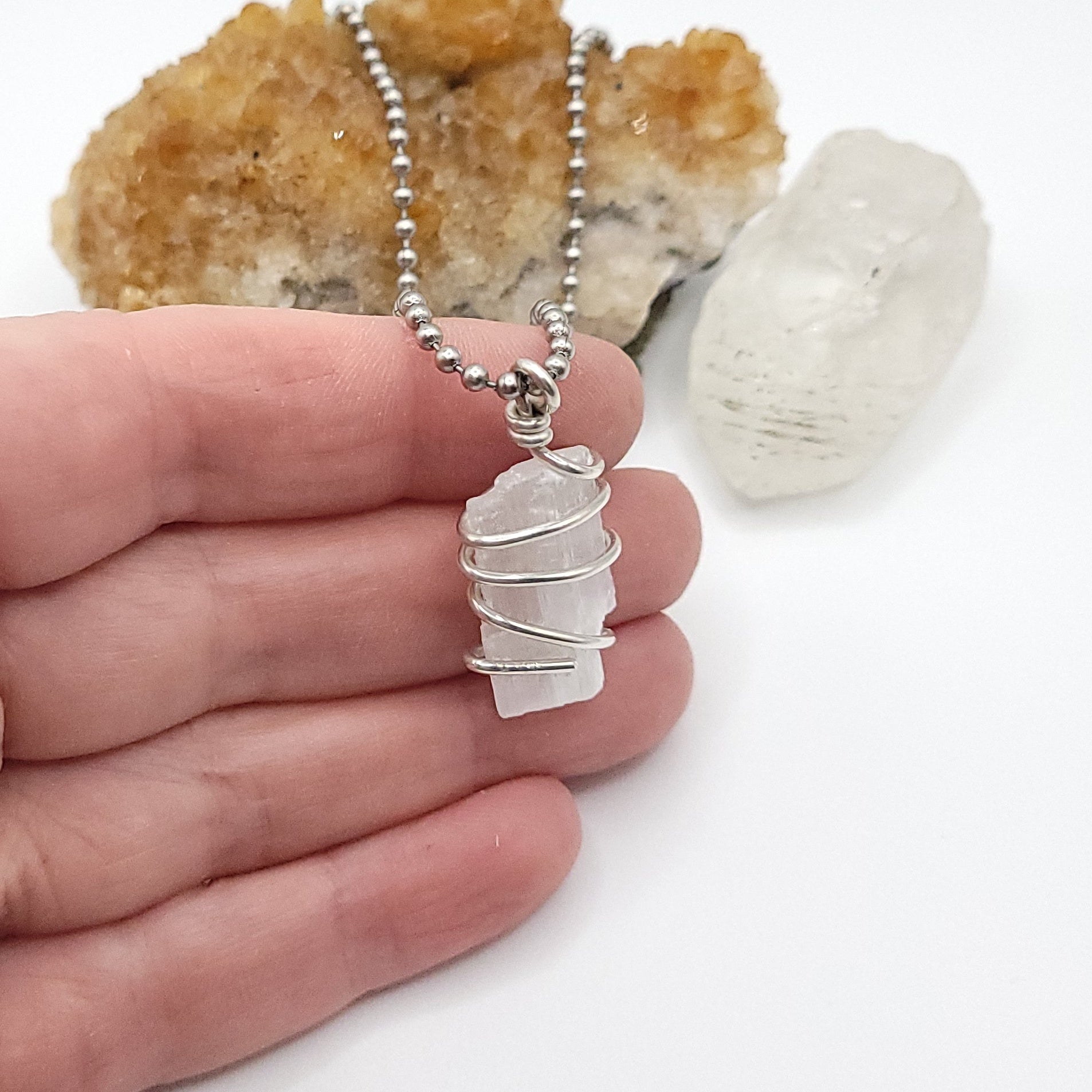 raw selenite necklace in sterling silver wire in hand , side view